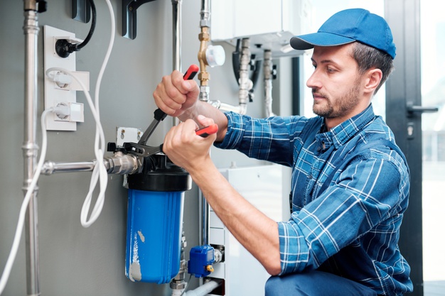 young-plumber-or-technician-in-workwear-using-pliers-while-installing-or-repairing-system-of-water-filtration_274679-5359.jpg